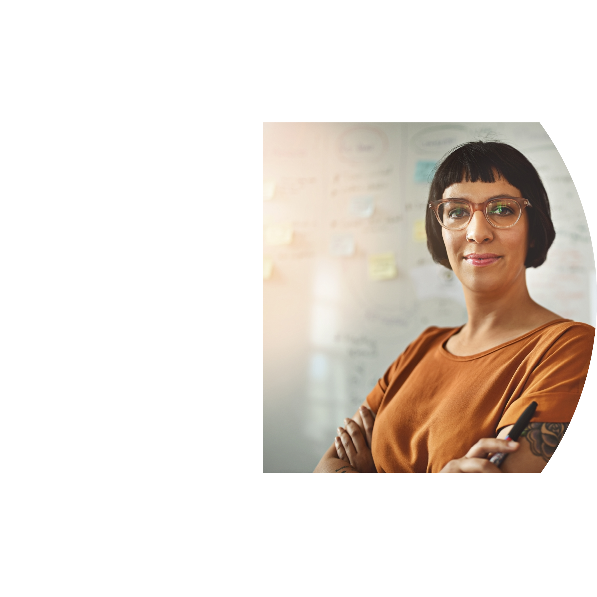 Cropped portrait of a young draftswoman standing with her arms folded in the office
