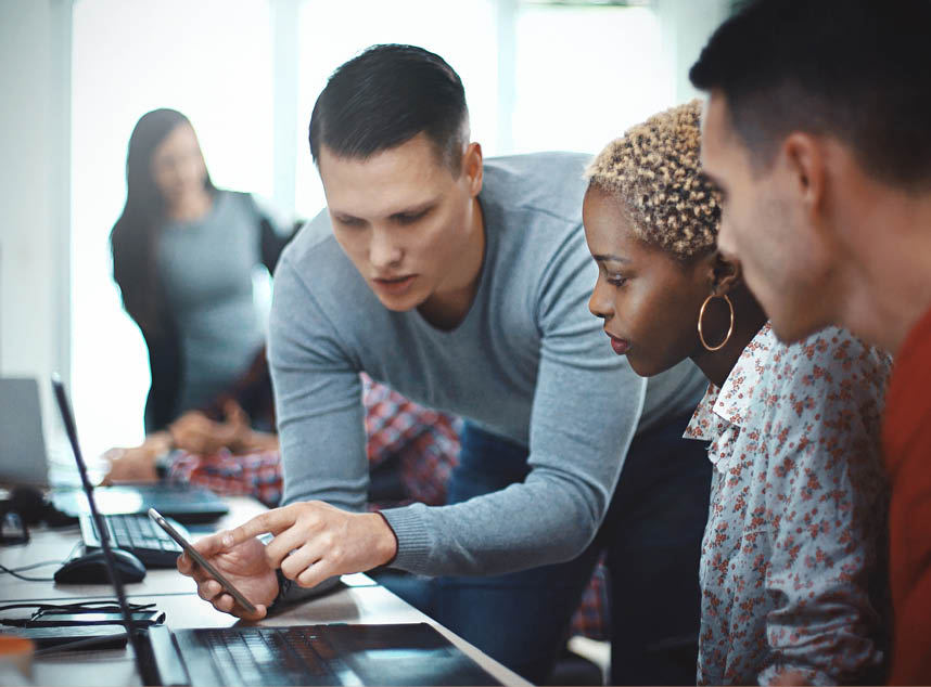 Closeup side view of group of mid 20's mobile application developers testing the code and fixing the issues 