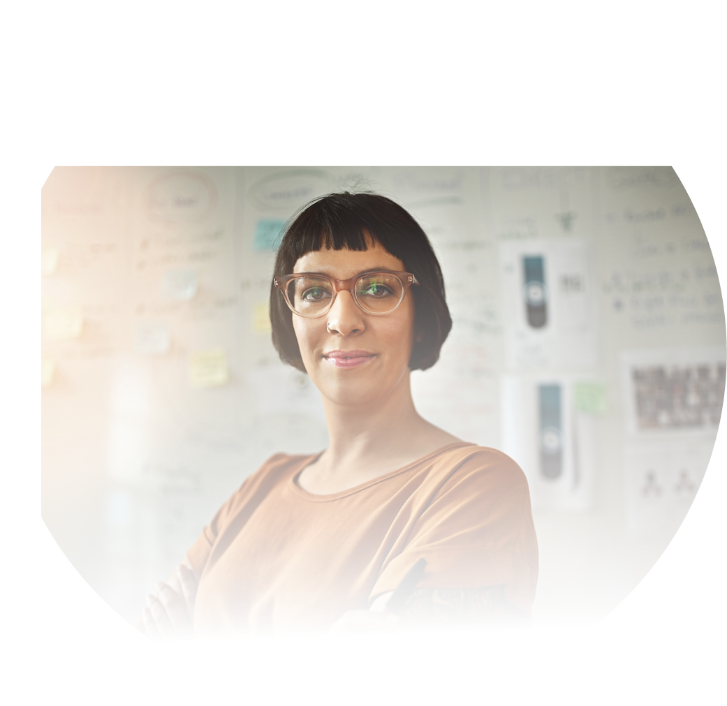 Cropped portrait of a young draftswoman standing with her arms folded in the office